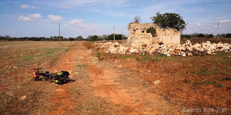 sentiero sterrato radura rossa rudere bicicletta serra specchia 768x384