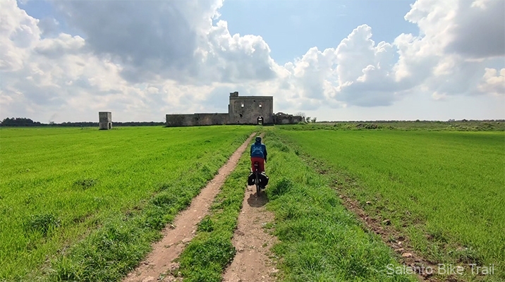 masseria rudere erba carrareccia cielo nuvole ciclista arneo
